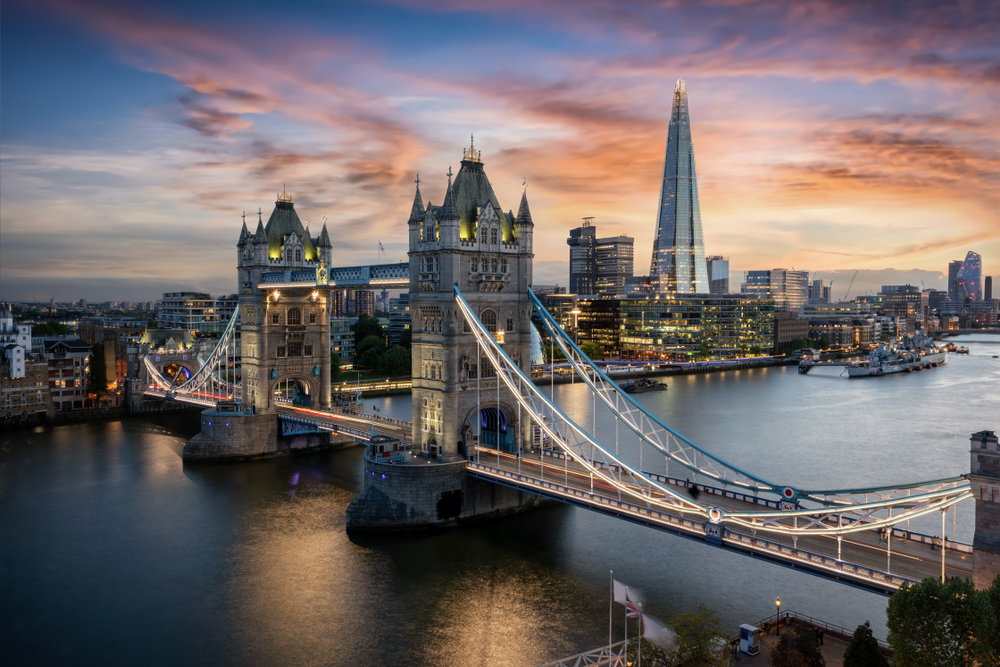 Aerial view to the illuminated Tower Bridge and skyline of London, UK, just after sunset