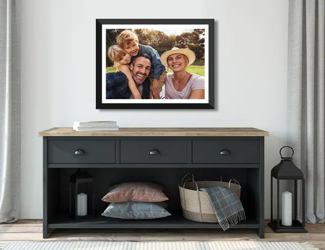 Family Portrait hanging over a cabinet with drawers and pillows 