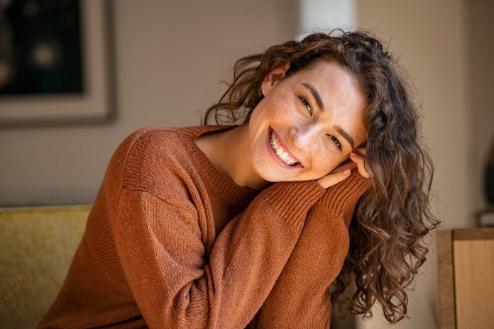 Happy young woman sitting on sofa