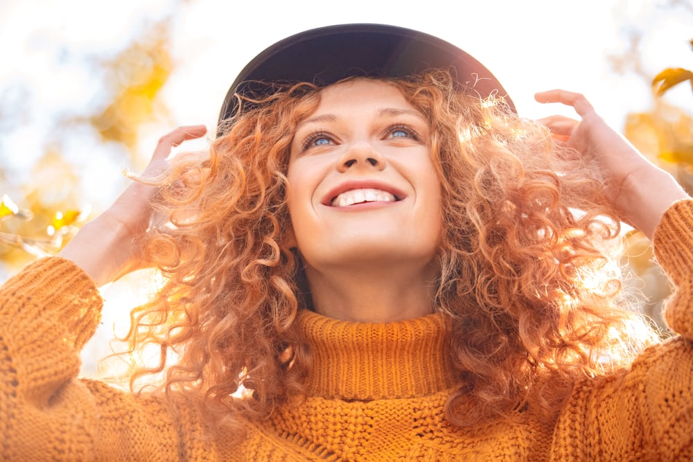 Low angle portrait of ginger adult women wearing in knitted orange sweater