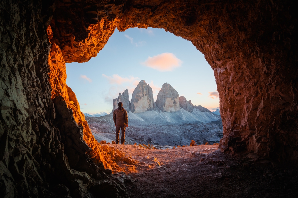 Tre Cime Di Lavaredo peaks in incredible orange sunset light. View from the cave in mountain against Three peaks of Lavaredo, Dolomite Alps, Italy, Europe.