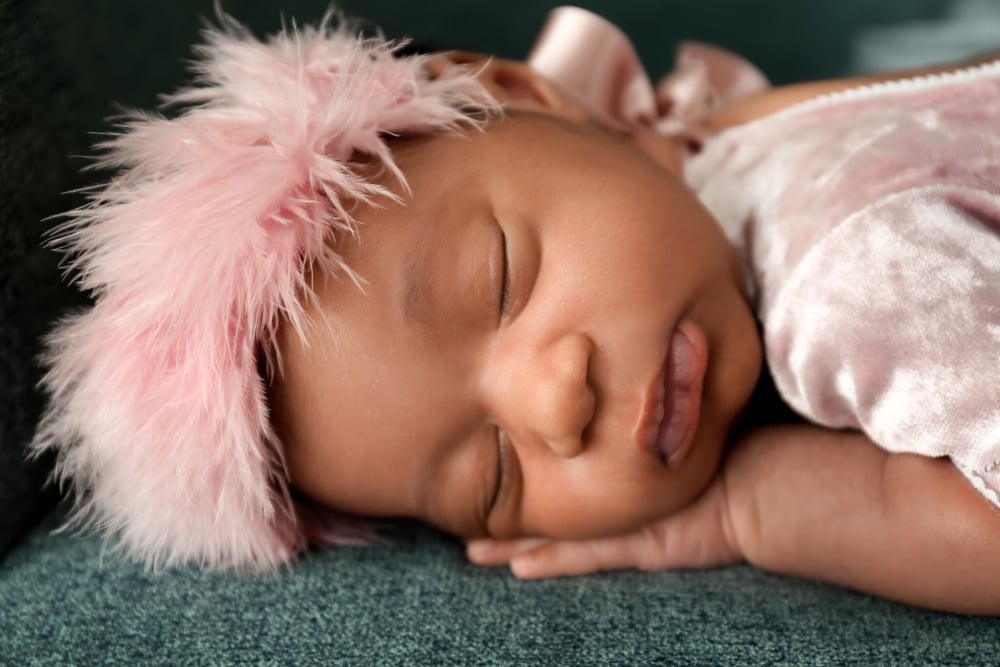 Newborn baby girl with pink feather headband