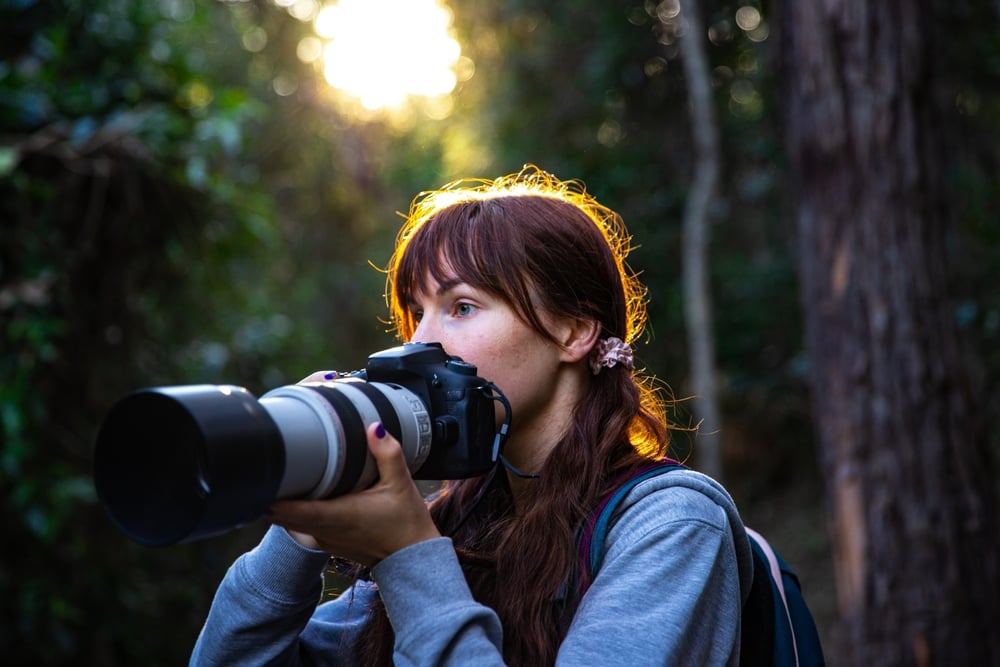 Woman taking photos with a telephoto lens