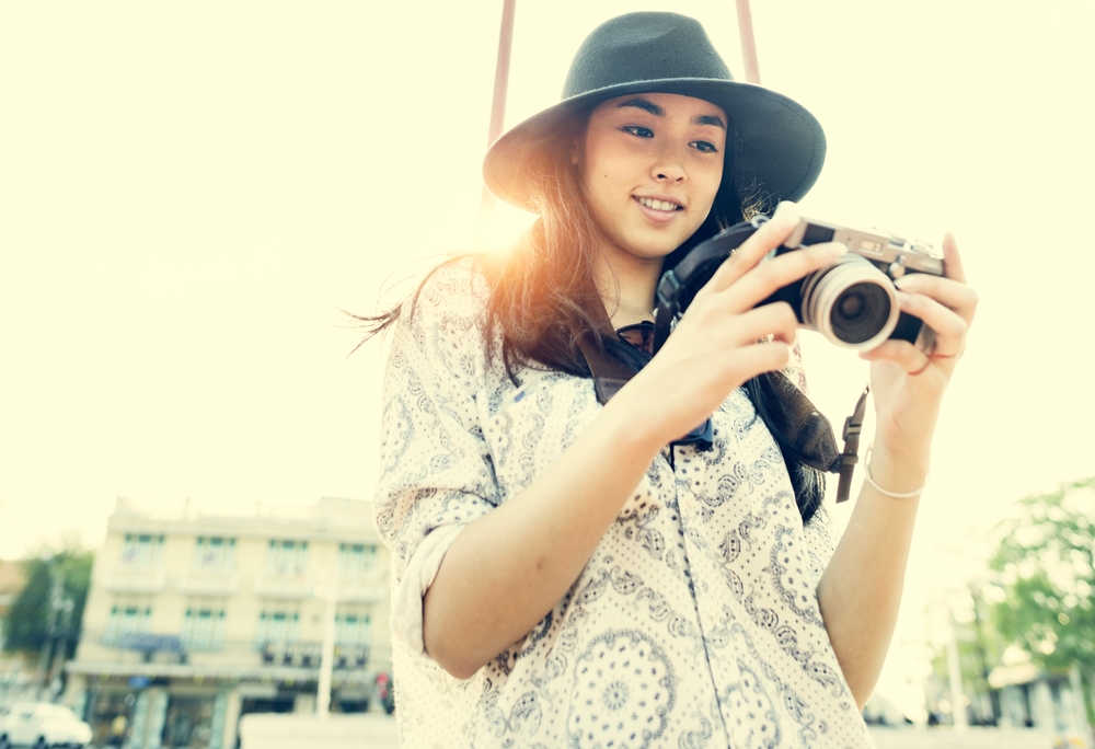 Woman using mirrorless camera for urban photography