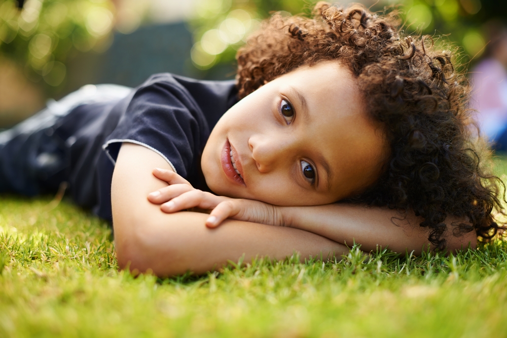 child lying on the grass 