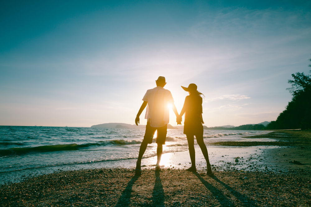 couple enjoying beautiful sunset walk on the beach 