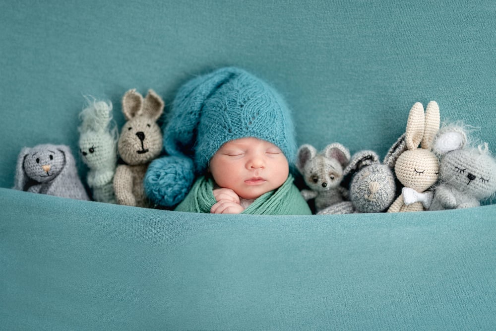 newborn sleeping with knitted toys