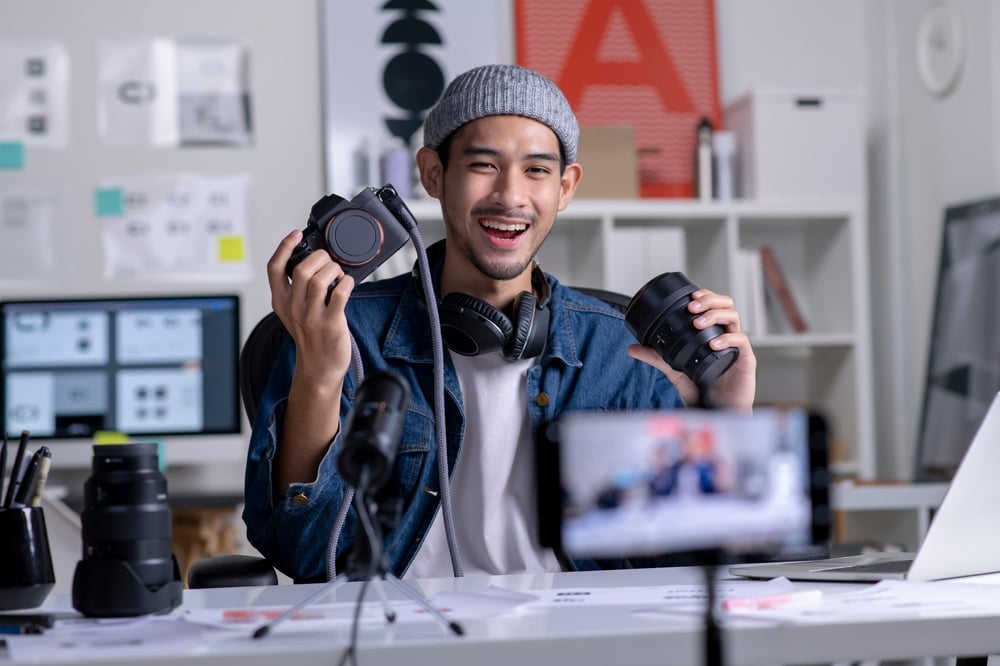 Young Asian man filming a camera tutorial