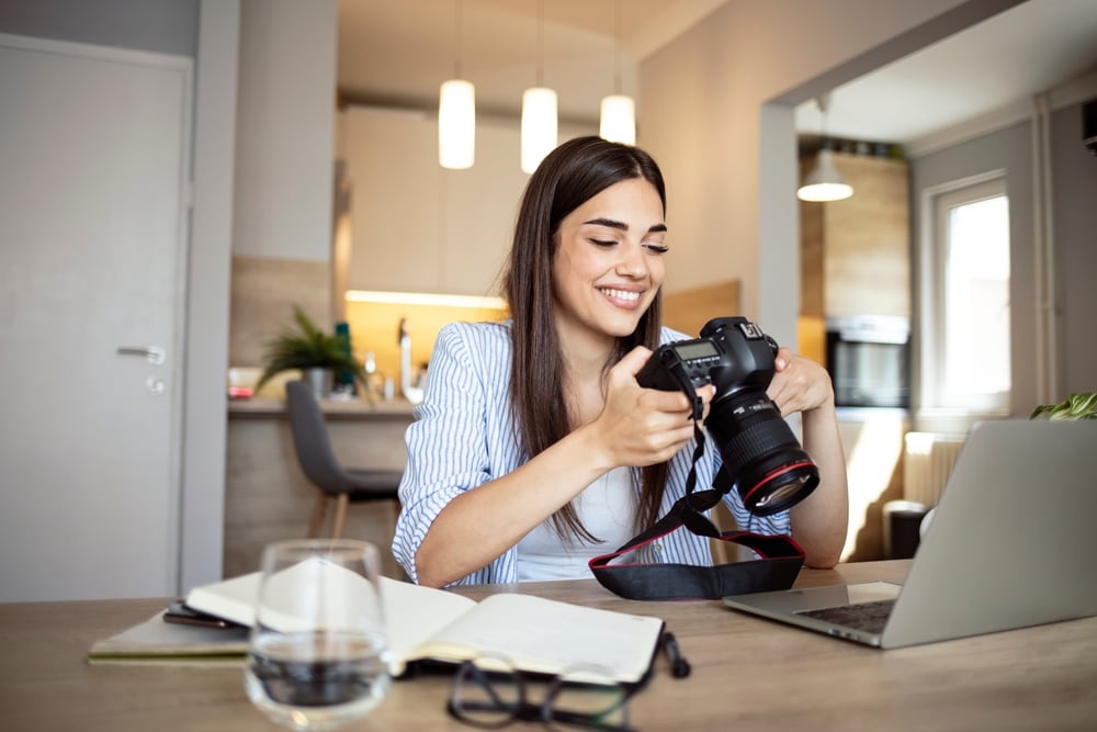 photographer holding a dslr camera in her home office